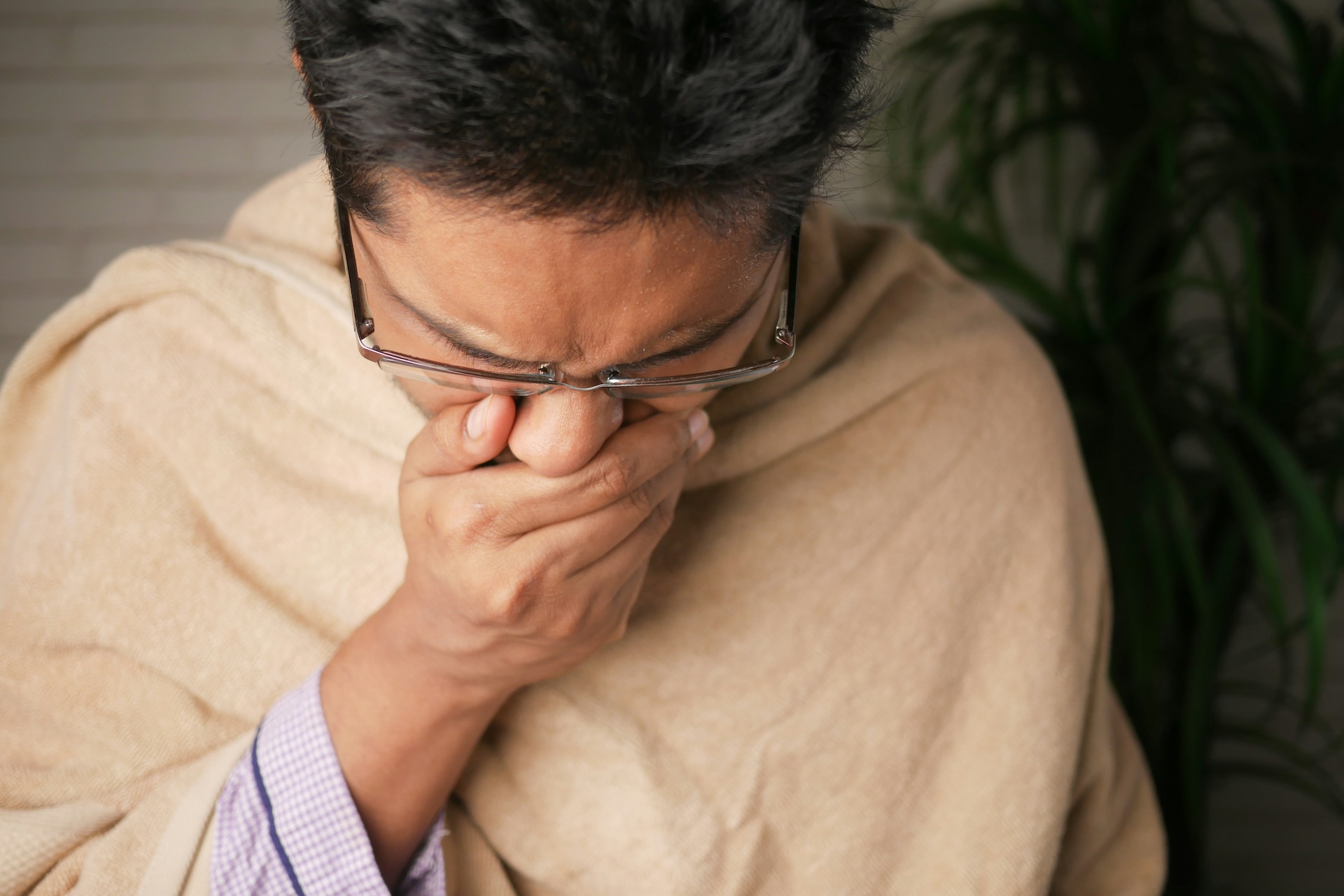 Man coughing while covering his mouth with his hand