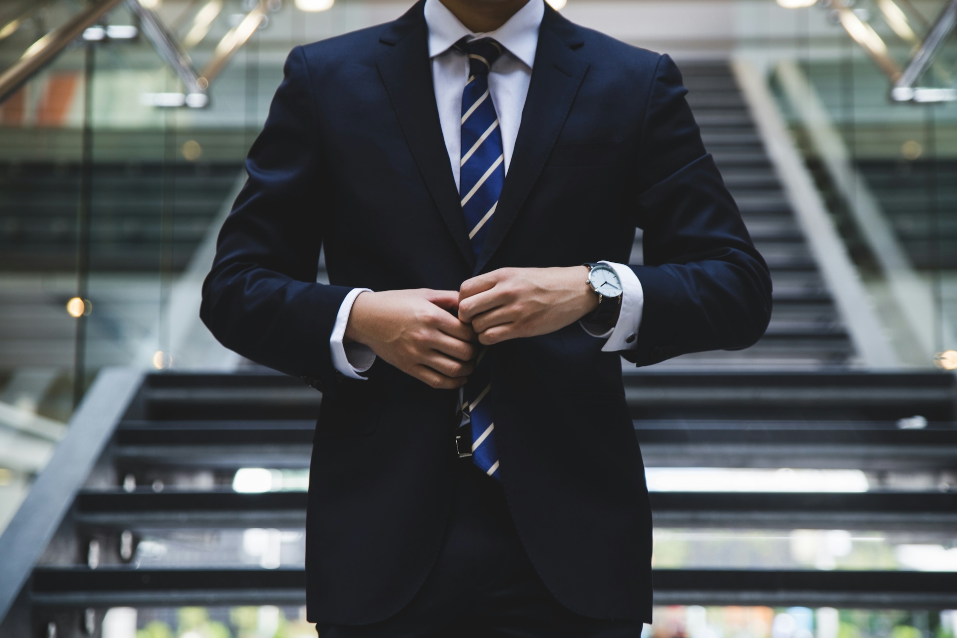 A man in a suit standing on stairs
